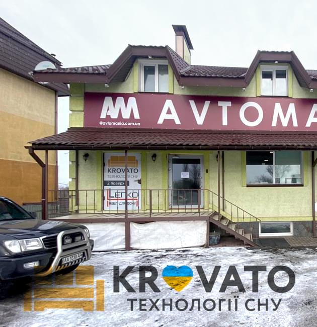 Двоповерхова зелена будівля магазину Krovato.